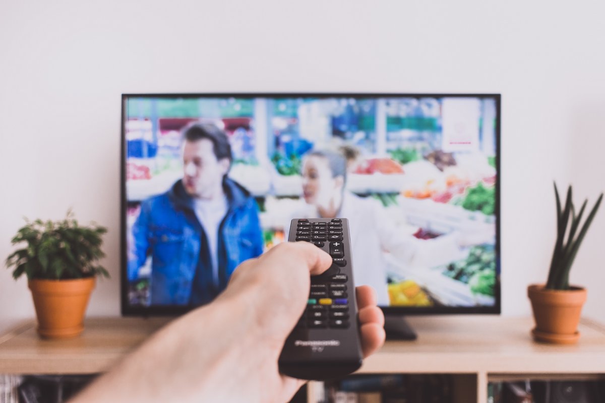 Télécommande devant streaming sur TV, car Netflix va augmenter son temps de publicité